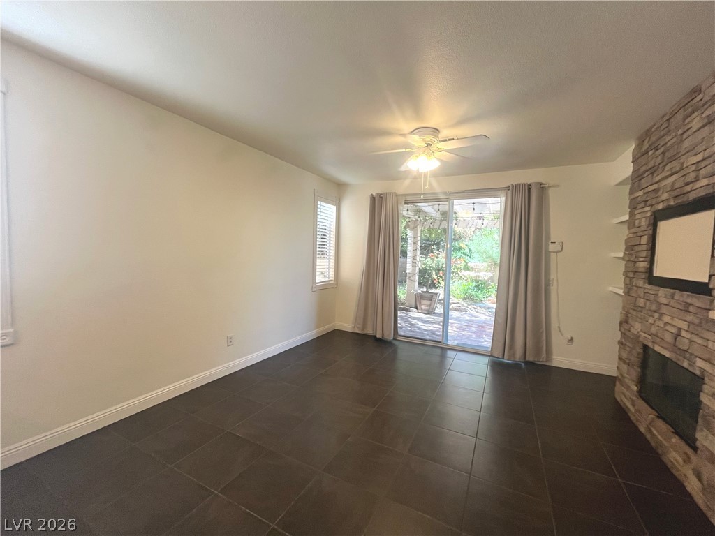 1809 Snow Spring Lane Las Vegas, NV 89134 - Photo 22 of 75 The family room open to the kitchen w/stoned fireplace, ceiling fan & light, ceramic tile floors and two tone paint.