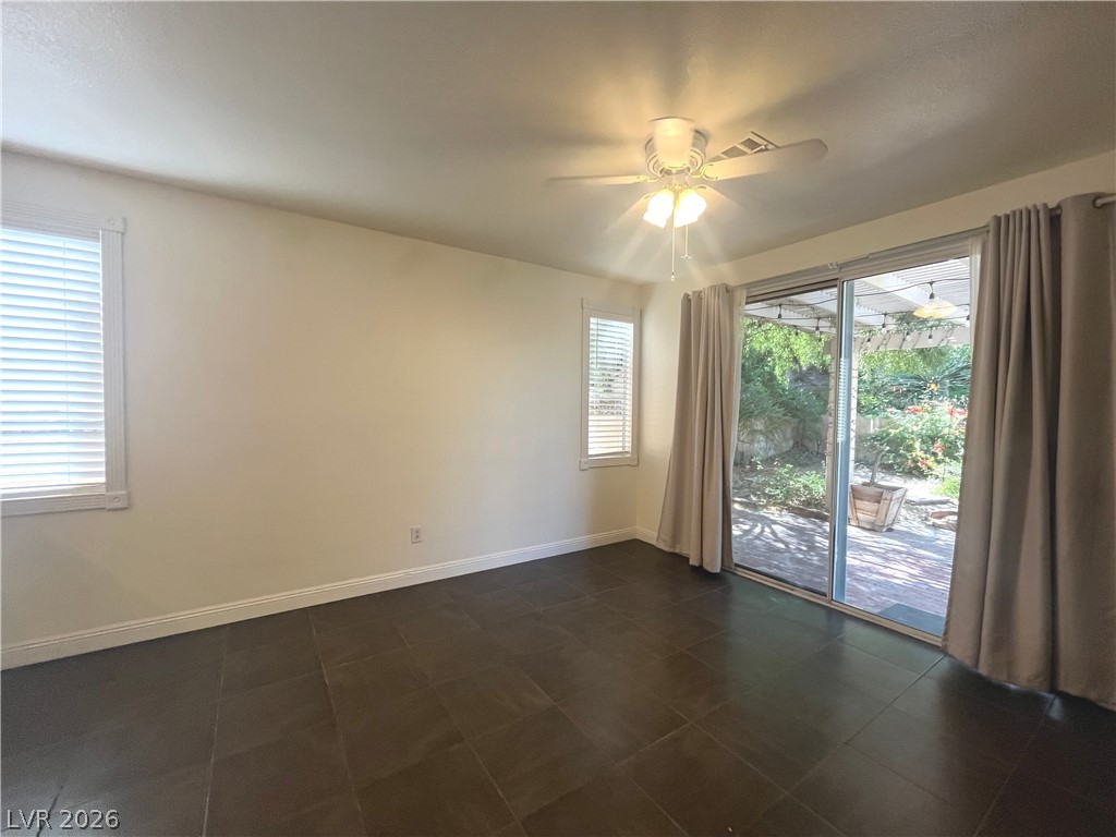 1809 Snow Spring Lane Las Vegas, NV 89134 - Photo 23 of 75 The family room open to the kitchen w/stoned fireplace, ceiling fan & light, ceramic tile floors and two tone paint.