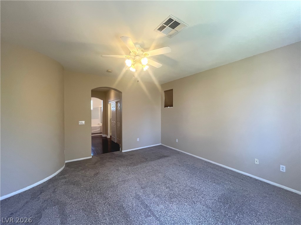 1809 Snow Spring Lane Las Vegas, NV 89134 - Photo 28 of 75 Primary bedroom w/ceiling fan & light, new carpet, two tone paint and walk in closet