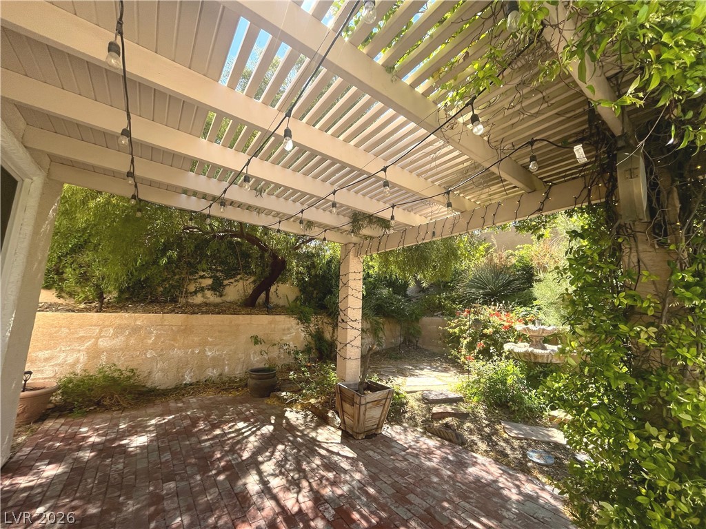1809 Snow Spring Lane Las Vegas, NV 89134 - Photo 56 of 75 Step outside to the covered patio w/lush landscaping & indulge in the inviting pool or unwind in the soothing spa—a fantastic setting for relaxation and outdoor enjoyment.
