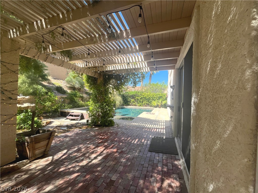 1809 Snow Spring Lane Las Vegas, NV 89134 - Photo 59 of 75 Step outside to the covered patio w/lush landscaping & indulge in the inviting pool or unwind in the soothing spa—a fantastic setting for relaxation and outdoor enjoyment.