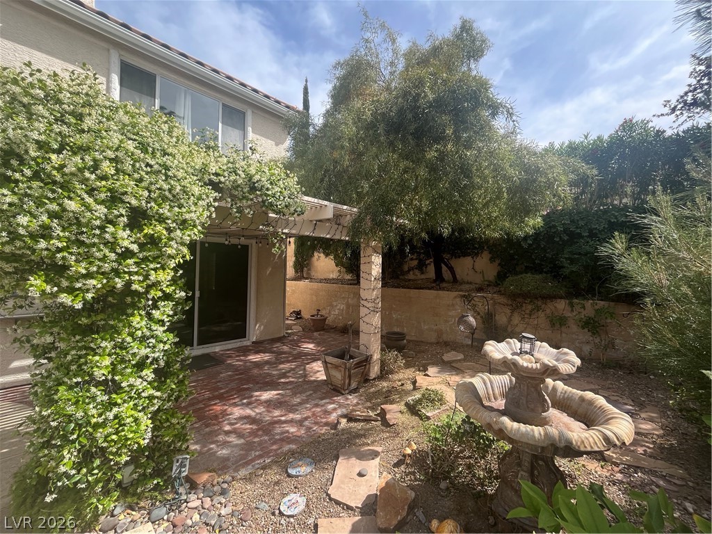 1809 Snow Spring Lane Las Vegas, NV 89134 - Photo 59 of 79 Step outside to the covered patio w/lush landscaping & indulge in the inviting pool or unwind in the soothing spa—a fantastic setting for relaxation and outdoor enjoyment.