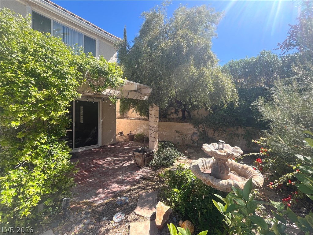 1809 Snow Spring Lane Las Vegas, NV 89134 - Photo 60 of 75 Step outside to the covered patio w/lush landscaping & indulge in the inviting pool or unwind in the soothing spa—a fantastic setting for relaxation and outdoor enjoyment.