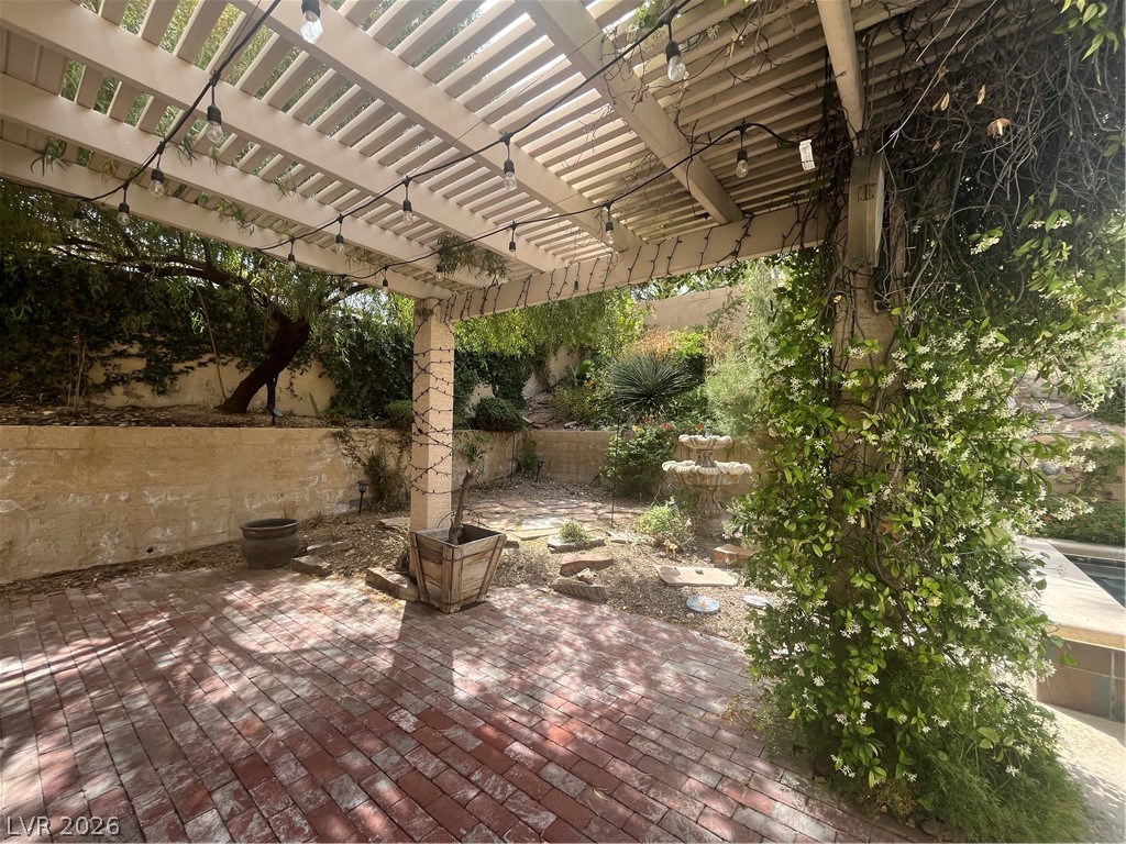 1809 Snow Spring Lane Las Vegas, NV 89134 - Photo 62 of 79 Step outside to the covered patio w/lush landscaping & indulge in the inviting pool or unwind in the soothing spa—a fantastic setting for relaxation and outdoor enjoyment.