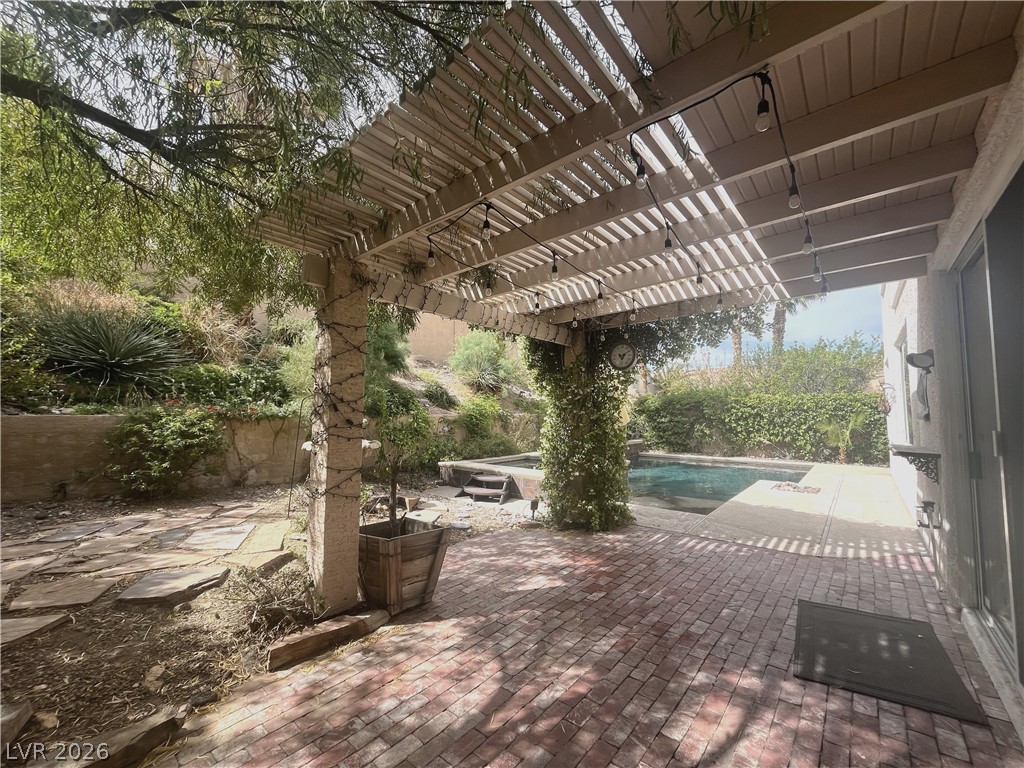 1809 Snow Spring Lane Las Vegas, NV 89134 - Photo 63 of 79 Step outside to the covered patio w/lush landscaping & indulge in the inviting pool or unwind in the soothing spa—a fantastic setting for relaxation and outdoor enjoyment.
