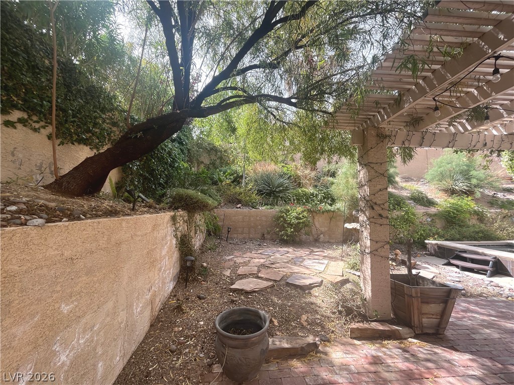 1809 Snow Spring Lane Las Vegas, NV 89134 - Photo 64 of 79 Step outside to the covered patio w/lush landscaping & indulge in the inviting pool or unwind in the soothing spa—a fantastic setting for relaxation and outdoor enjoyment.