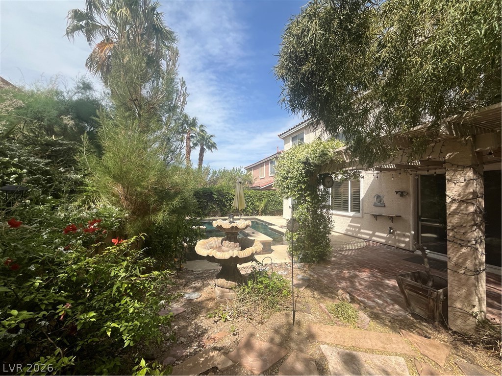 1809 Snow Spring Lane Las Vegas, NV 89134 - Photo 65 of 79 Step outside to the covered patio w/lush landscaping & indulge in the inviting pool or unwind in the soothing spa—a fantastic setting for relaxation and outdoor enjoyment.