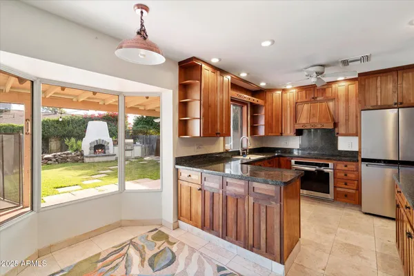 a kitchen with stainless steel appliances granite countertop a stove a refrigerator a sink and dishwasher