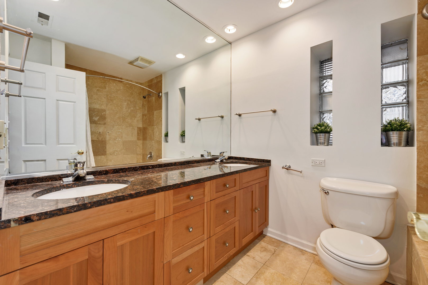 15 East Division Street, Unit 2W Chicago, IL 60611 - Photo 15 of 20 a bathroom with a granite countertop toilet sink and mirror
