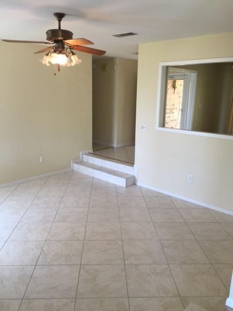 2055 Christensen Drive Navarre, FL 32566 - Photo 15 of 25 a view of an empty room with window and chandelier fan