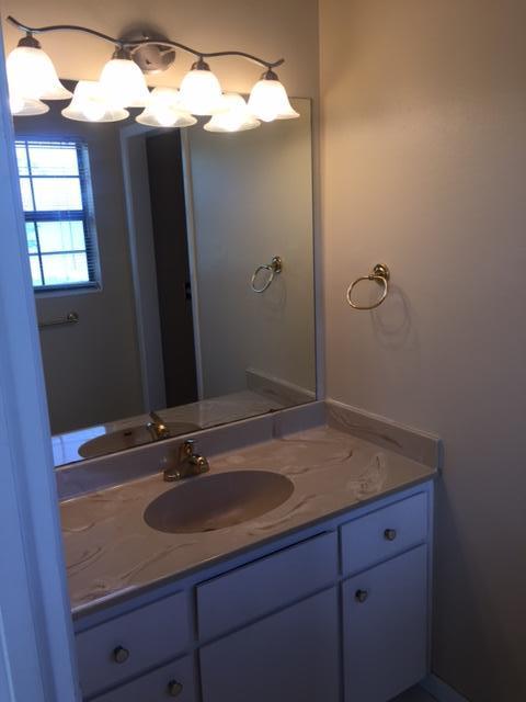 2055 Christensen Drive Navarre, FL 32566 - Photo 21 of 25 a bathroom with a granite countertop sink and a mirror