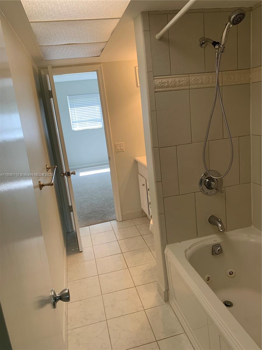 400 Northeast 20th Street, Unit A108 Boca Raton, FL 33431 - Photo 13 of 35 a bathroom with a tub a sink and mirror