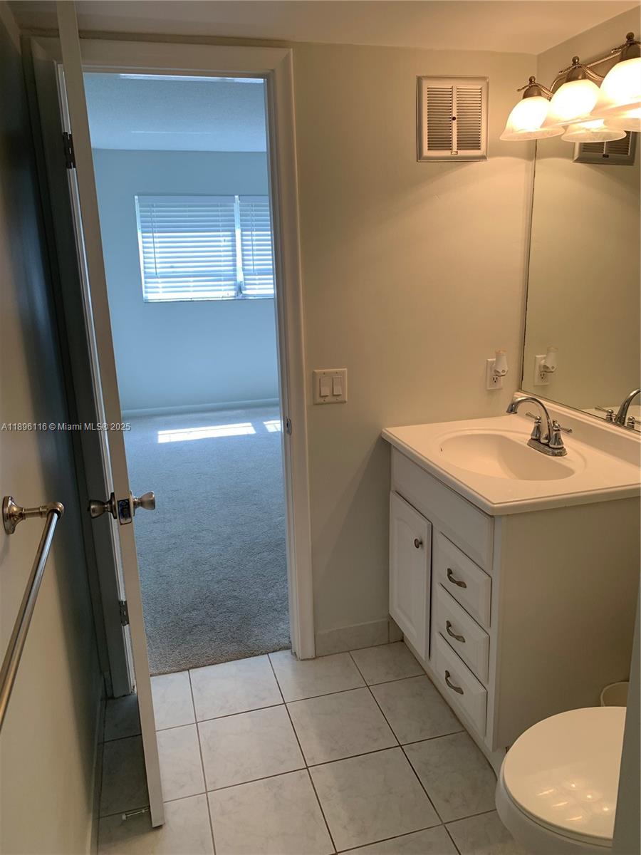 400 Northeast 20th Street, Unit A108 Boca Raton, FL 33431 - Photo 14 of 35 a bathroom with a sink a toilet and shower