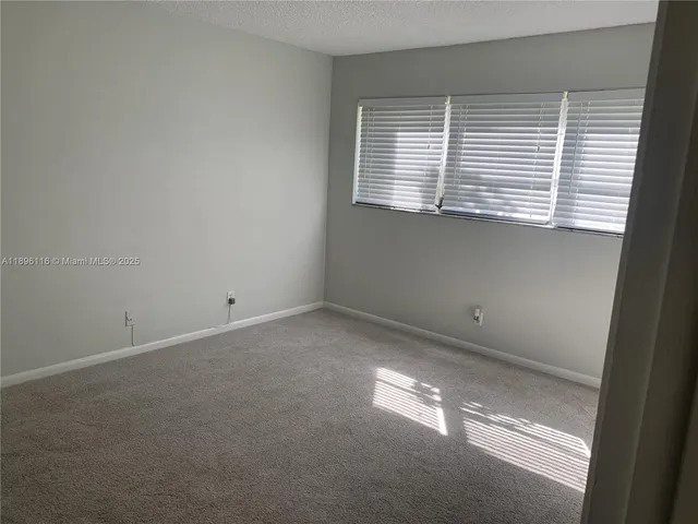 a view of a livingroom with an empty space and a window