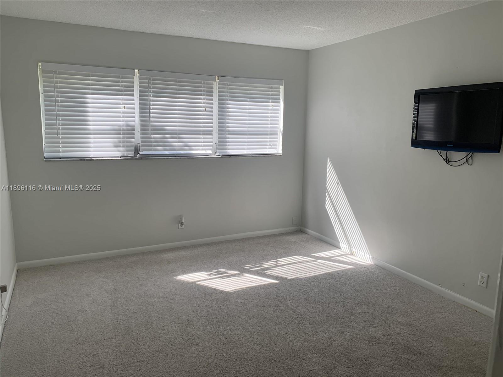 400 Northeast 20th Street, Unit A108 Boca Raton, FL 33431 - Photo 18 of 35 a view of a livingroom with an empty space and a window