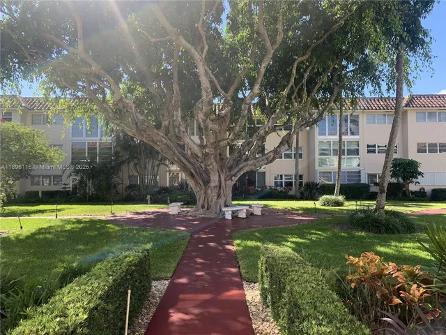 a view of a big building with a big yard and plants