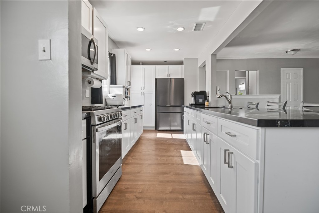 1555 Toluca Drive East San Bernardino, CA 92404 - Photo 5 of 13 a large kitchen with stainless steel appliances a sink and cabinets