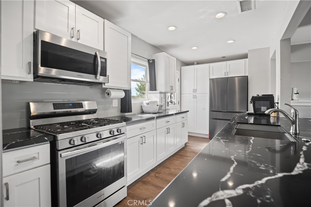 1555 Toluca Drive East San Bernardino, CA 92404 - Photo 6 of 13 a kitchen with stainless steel appliances granite countertop a stove a sink and a microwave
