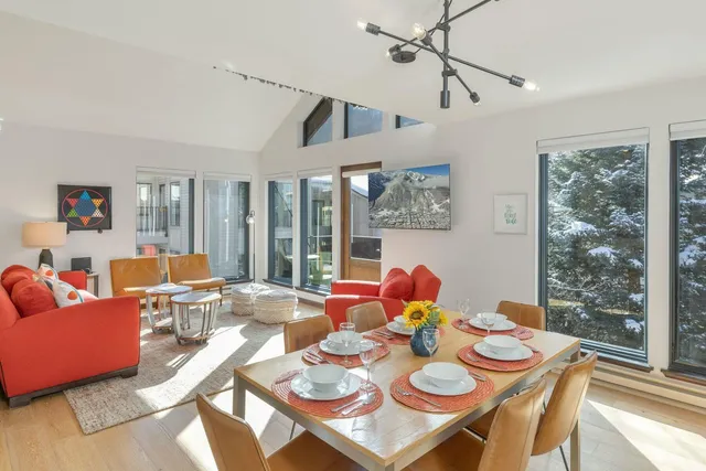 a living room with furniture a rug and kitchen view