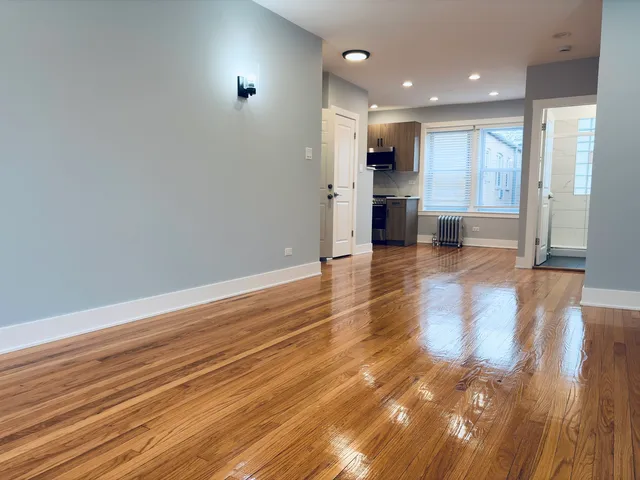 a view of a kitchen with wooden floor and a window