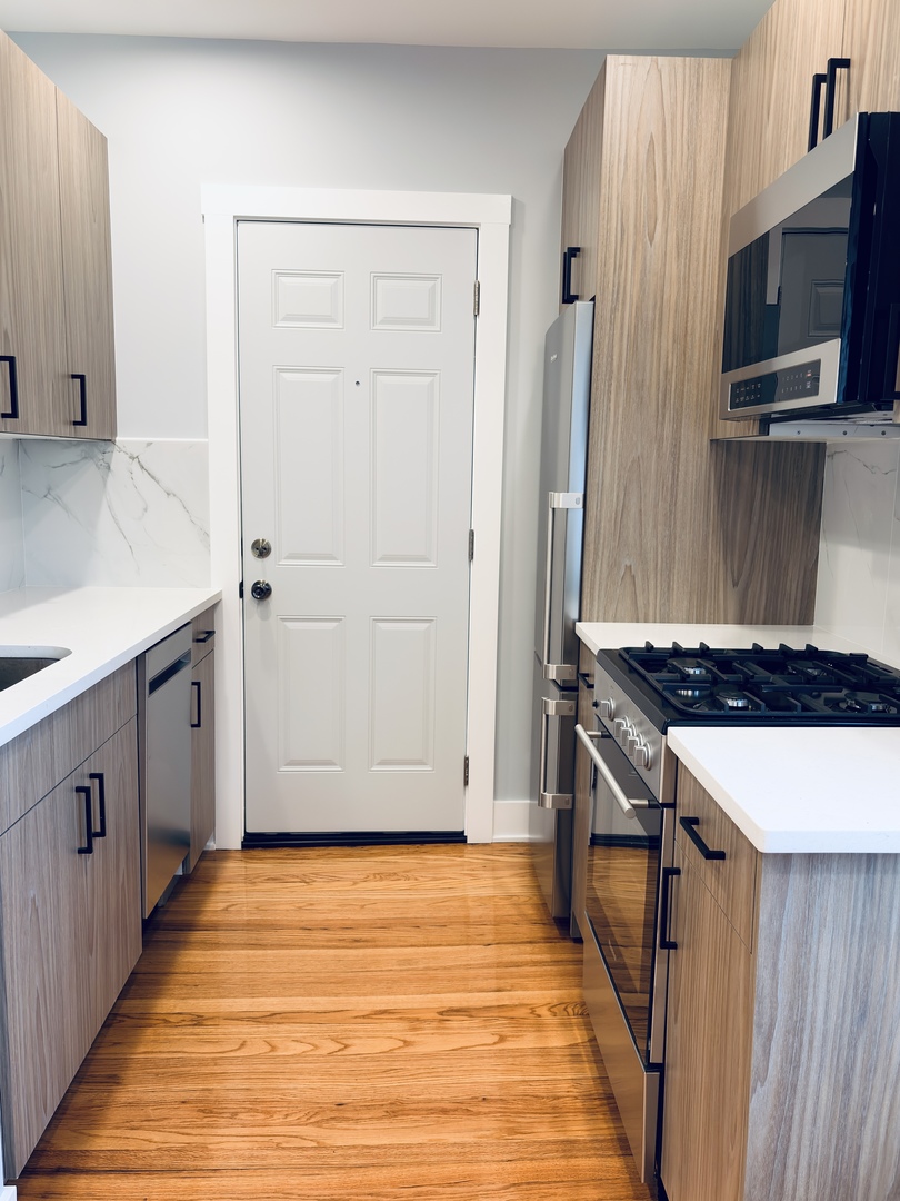 5060 North Wolcott Avenue, Unit 3E Chicago, IL 60640 - Photo 3 of 8 a kitchen with stainless steel appliances a stove and a refrigerator