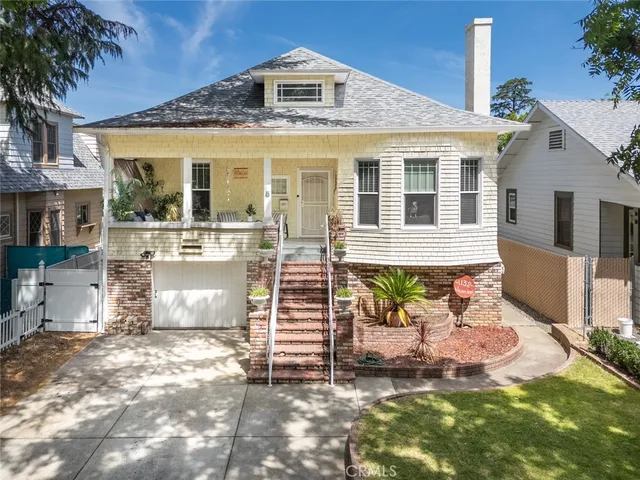a view of a house with a yard and sitting area
