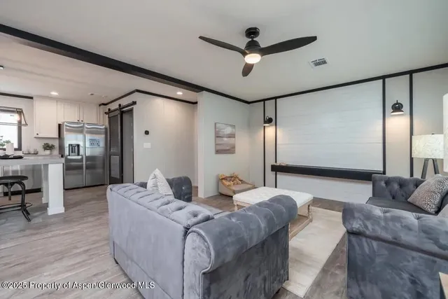 a living room with couch and a view of kitchen