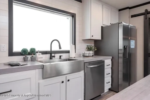 a kitchen with stainless steel appliances granite countertop a refrigerator and a sink