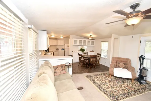 a large white kitchen with a stove a sink dishwasher and a refrigerator with wooden floor