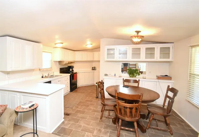 a kitchen with granite countertop a sink a stove and cabinets