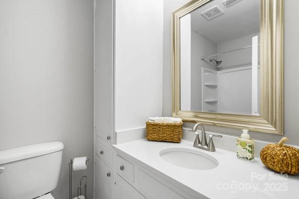 2707 Quailrush Road Charlotte, NC 28226 - Photo 21 of 29 a bathroom with a granite countertop sink a mirror and a toilet