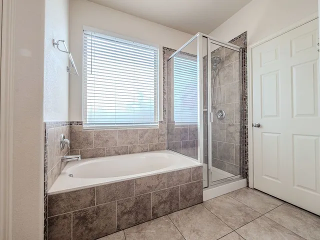 a spacious bathroom with a bathtub and shower