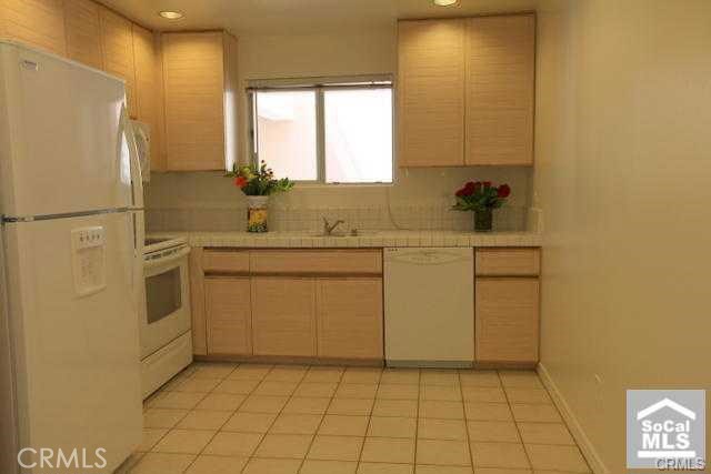 2233 Martin, Unit 300 Irvine, CA 92612 - Photo 3 of 25 a kitchen with a sink a stove a refrigerator and cabinets