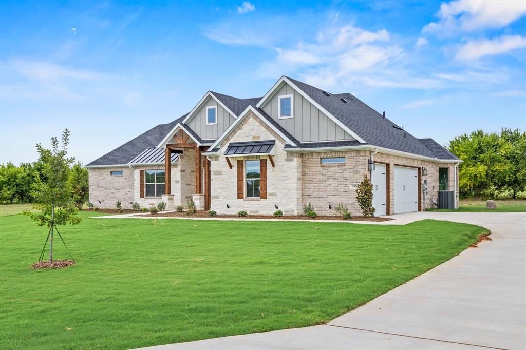 13743 Cashs Mill Road Sanger, TX 76266 - Photo 1 of 1 View of front of house featuring board and batten siding, concrete driveway, a front yard, roof with shingles, and stone siding