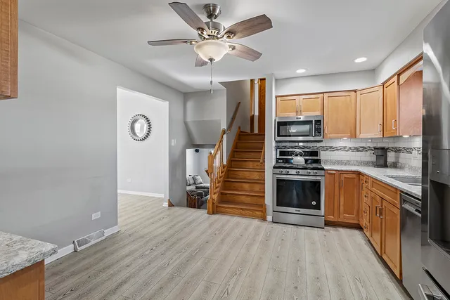 a kitchen with granite countertop a stove cabinets and wooden floor