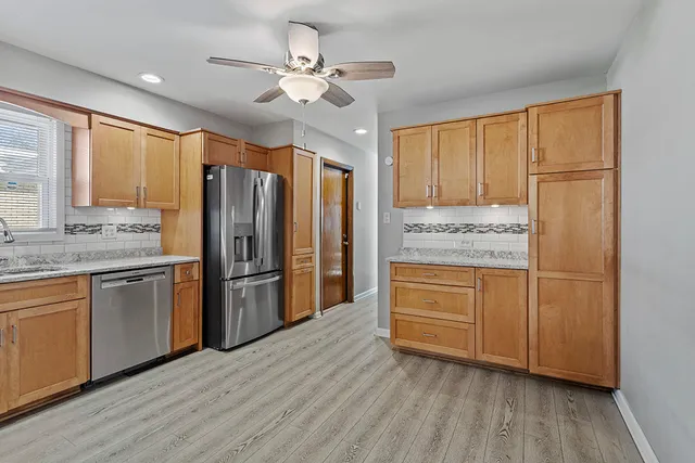 a kitchen with stainless steel appliances granite countertop cabinets and wooden floor