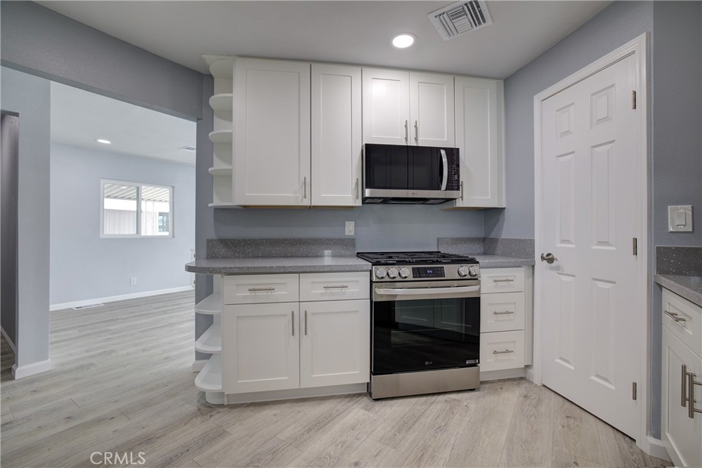 3700 Buchanan Street, Unit 131 Corona, CA 92503 - Photo 13 of 27 a kitchen with stainless steel appliances granite countertop a stove and a microwave