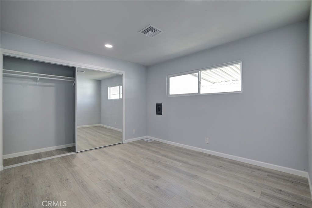 3700 Buchanan Street, Unit 131 Corona, CA 92503 - Photo 19 of 27 an empty room with wooden floor and windows