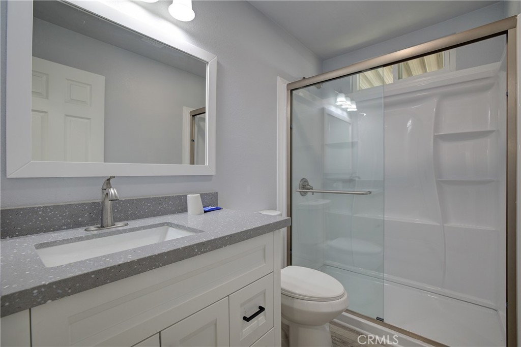 3700 Buchanan Street, Unit 131 Corona, CA 92503 - Photo 21 of 27 a bathroom with a granite countertop sink a toilet and shower