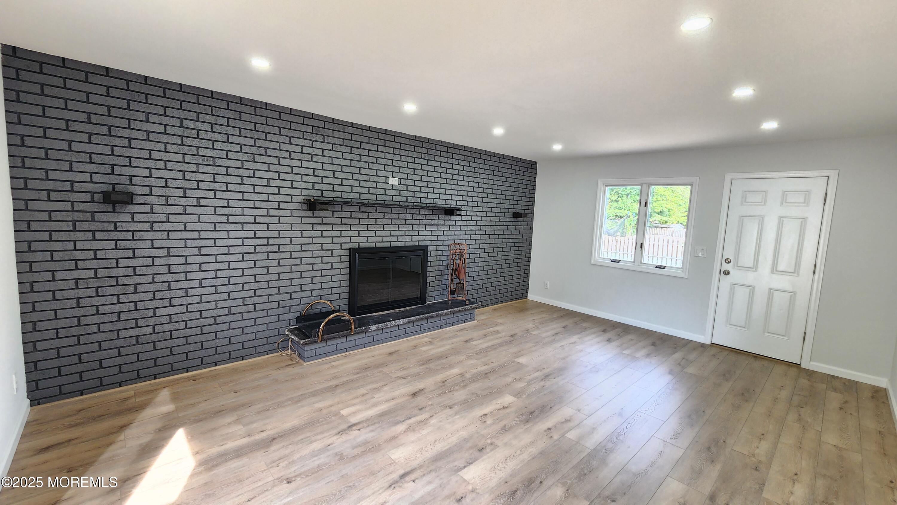 34 Hemlock Street Hazlet, NJ 07730 - Photo 11 of 30 a view of empty room with wooden floor and fireplace