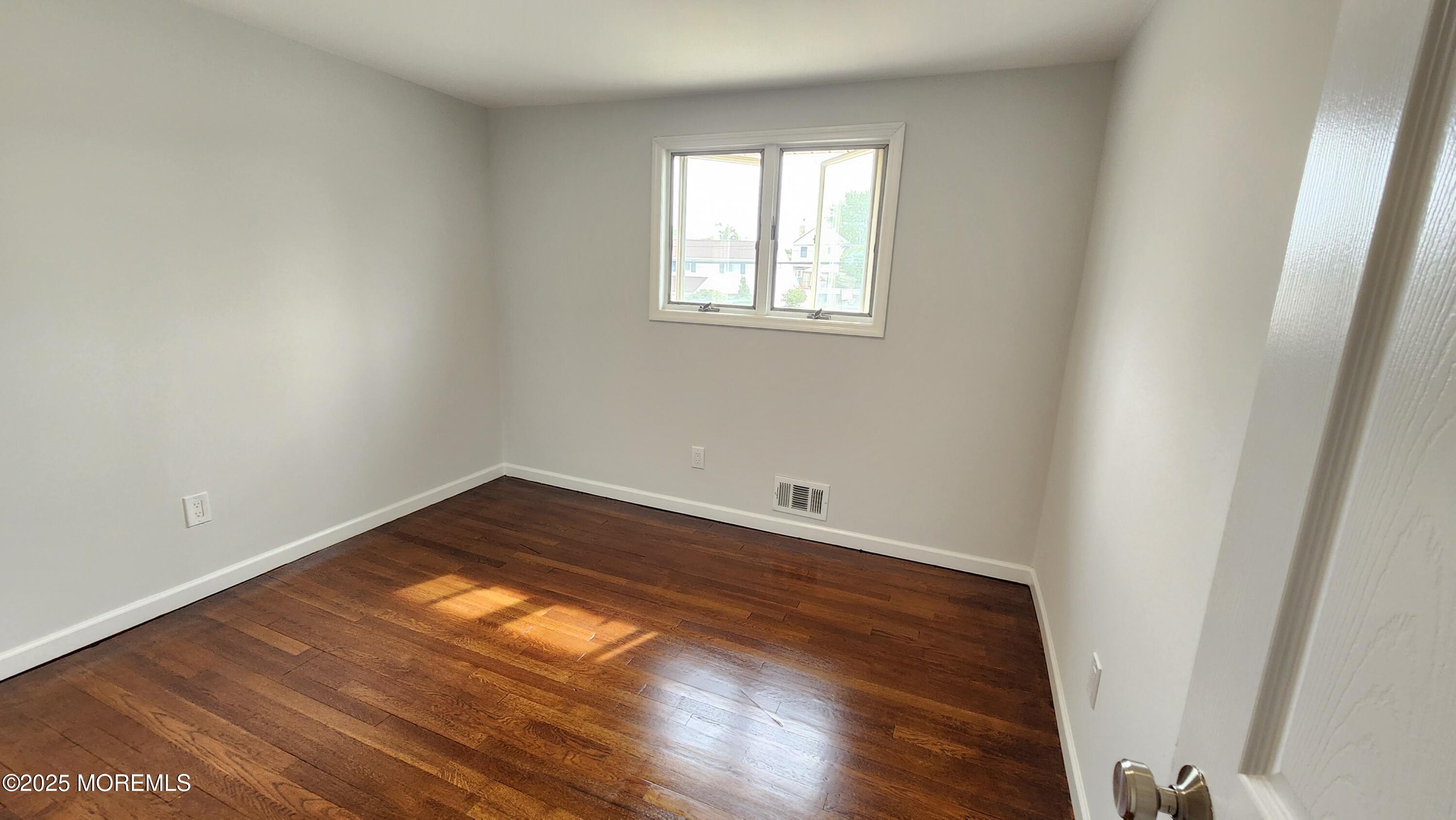 34 Hemlock Street Hazlet, NJ 07730 - Photo 14 of 30 wooden floor in an empty room with a window