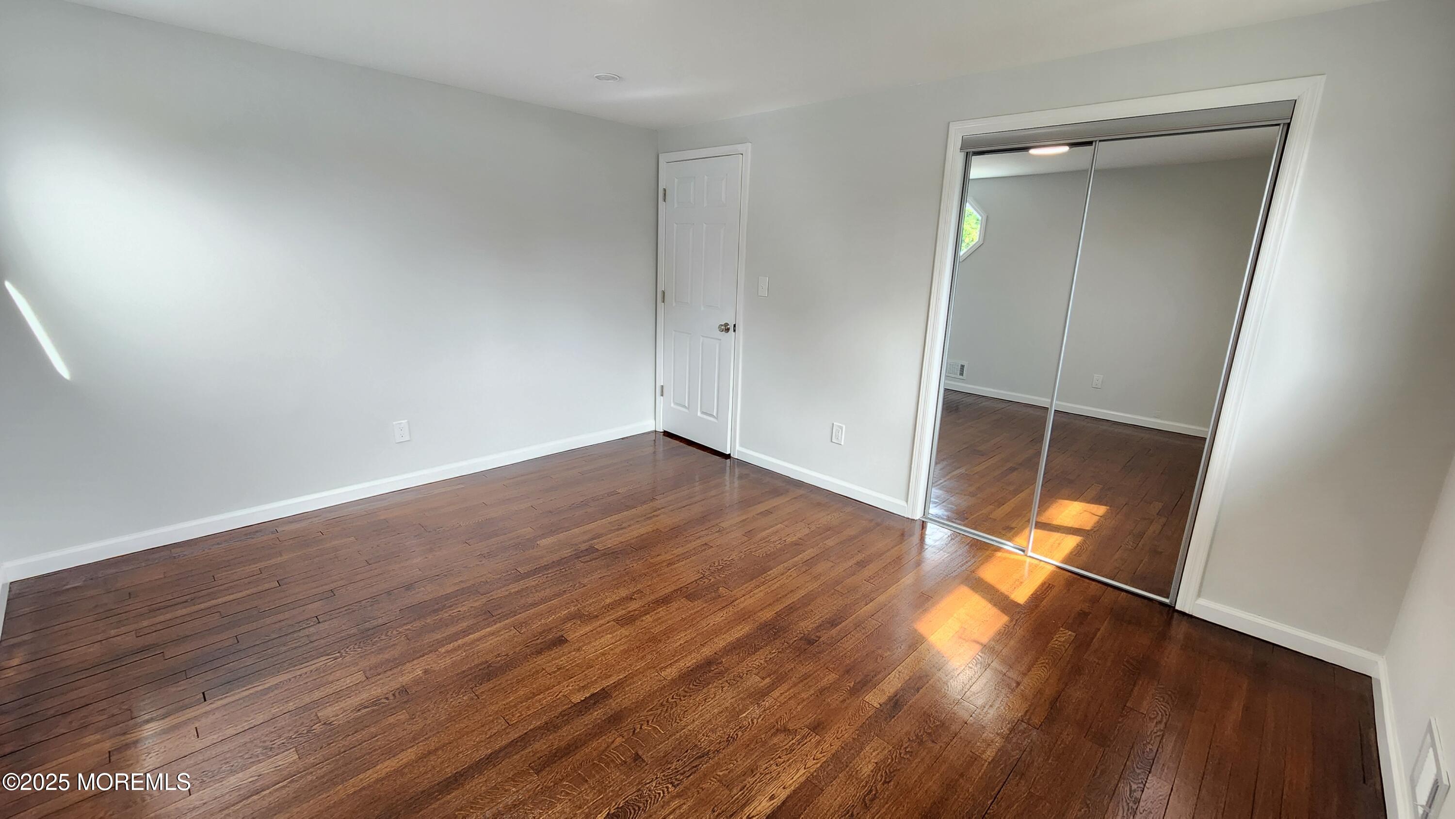 34 Hemlock Street Hazlet, NJ 07730 - Photo 15 of 30 a view of an empty room with wooden floor and a window