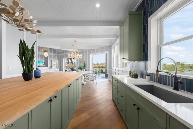a kitchen with sink and view of living room
