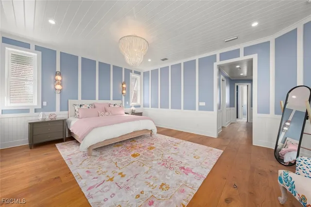 a bedroom with a large bed and a chandelier