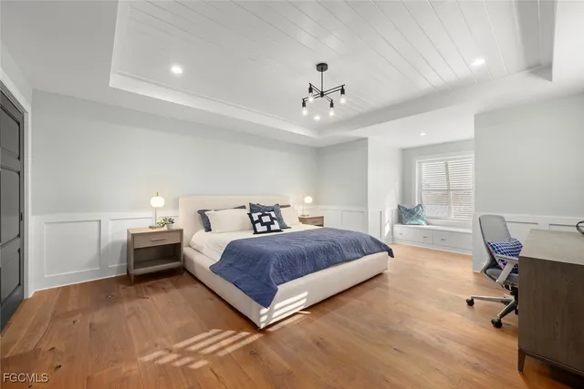 a bedroom with a bed and a chandelier