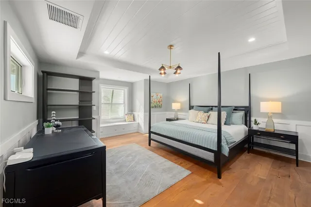 a bedroom with a bed and a chandelier