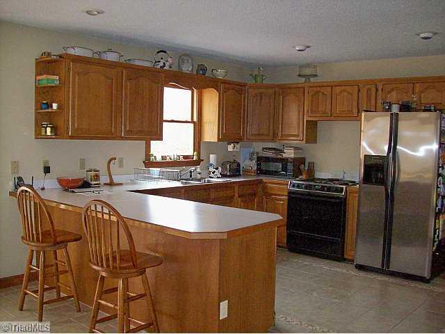 156 McDaniel Road Advance, NC 27006 - Photo 4 of 8 Kitchen. Open kitchen with bar area. Lots of counterspace. Dishwasher, range/oven and refrigerator to remain.