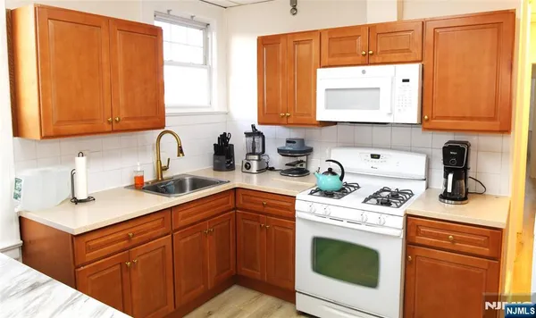 a kitchen with stainless steel appliances granite countertop a sink a stove and cabinets