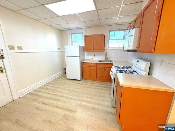a kitchen with a refrigerator a stove a sink dishwasher and wooden cabinets