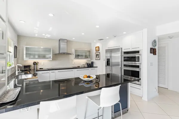 a kitchen with stainless steel appliances granite countertop a stove refrigerator and cabinets